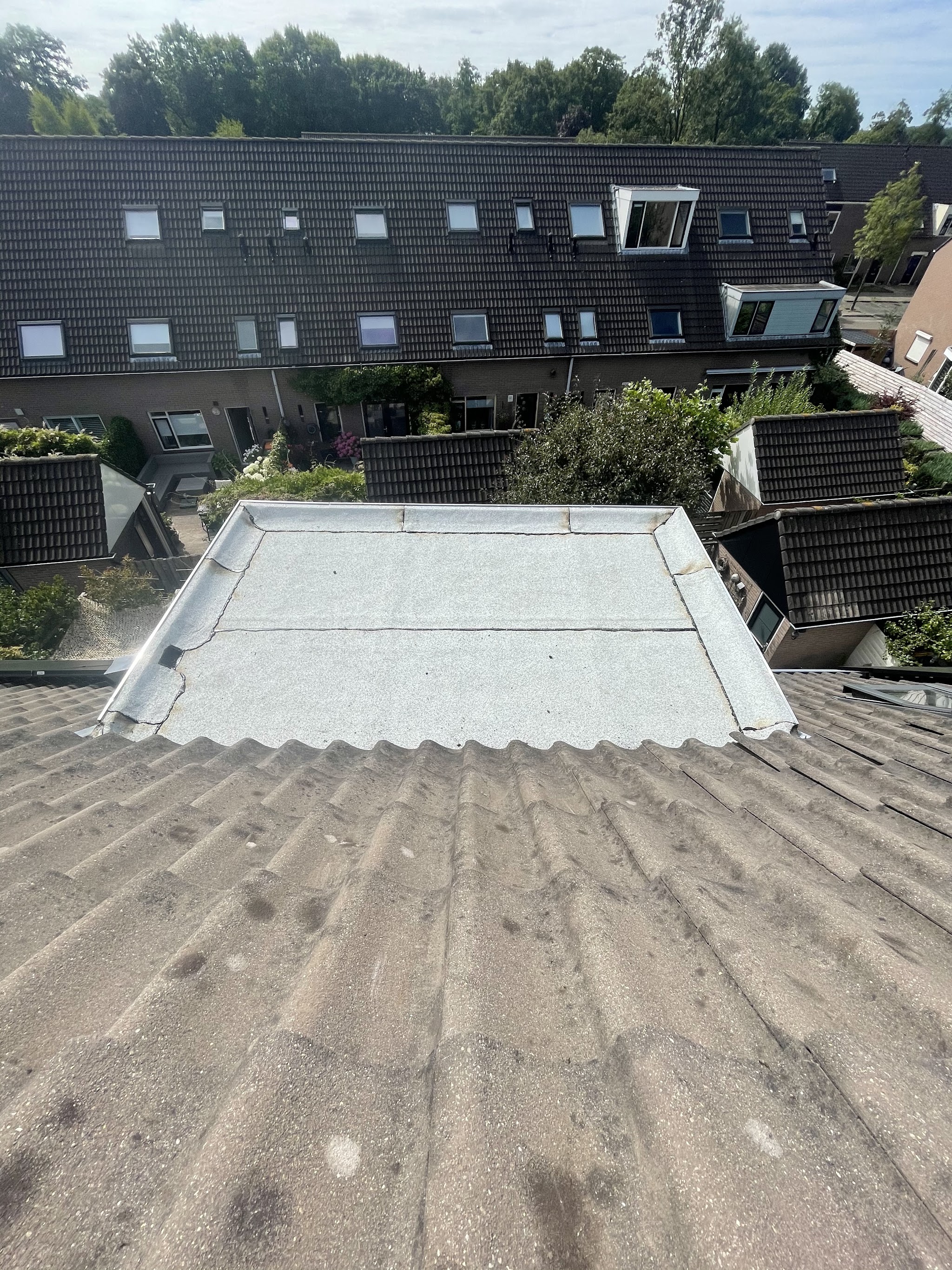 Afgewerkt dakkapeldak in nieuwe dakbedekking, met de straat erachter